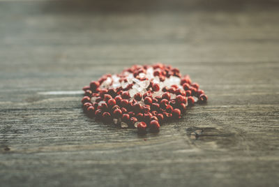 Close-up of pink peppercorns and rock salt on table