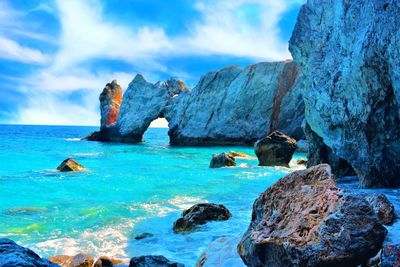 Rock formation in sea against sky