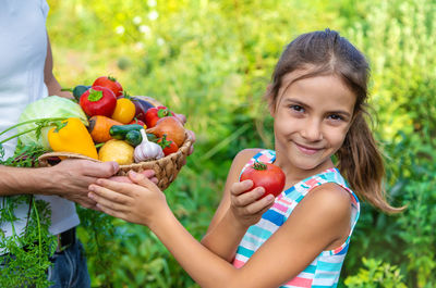 Grandmother giving vegetables to granddaughter