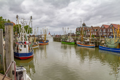 Boats moored in river against sky