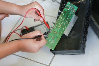 Cropped hands repairing motherboard