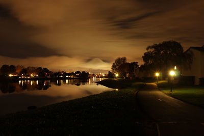 Scenic view of city illuminated at waterfront during night 