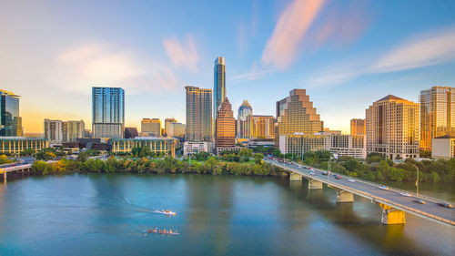 River amidst buildings in city against sky