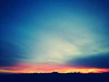 Scenic view of silhouette landscape against blue sky