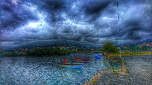 Scenic view of river against cloudy sky