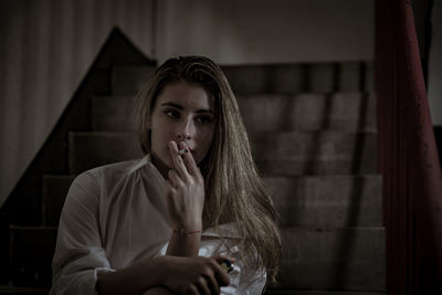 Young woman smoking cigarette on steps