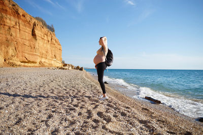 Full length of woman on beach against sky