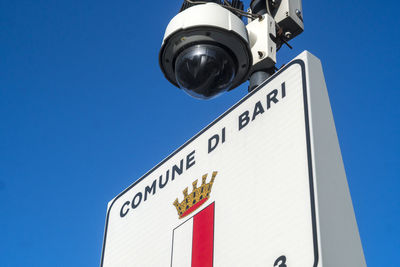 Low angle view of information sign against clear blue sky