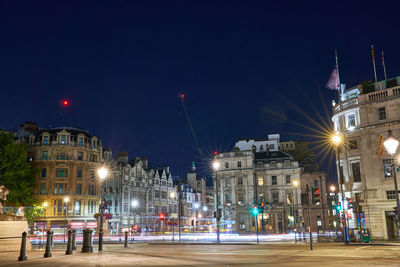 Illuminated buildings against sky at night