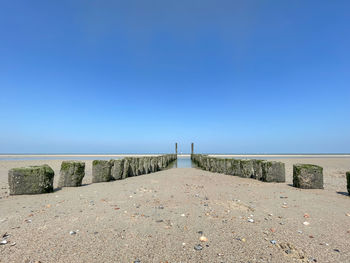 Scenic view of beach against clear blue sky