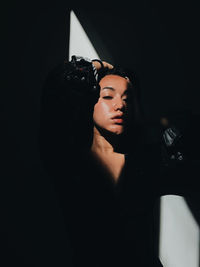 Portrait of young woman standing in darkroom