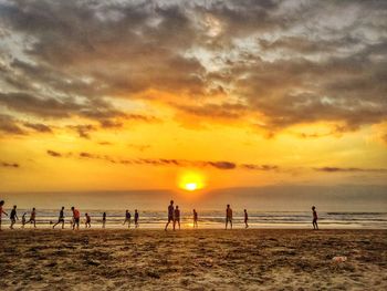 Group of people on beach at sunset