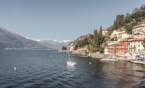 Scenic view of sea by buildings against clear sky