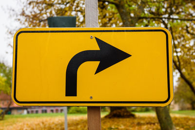 Close-up of arrow sign on road