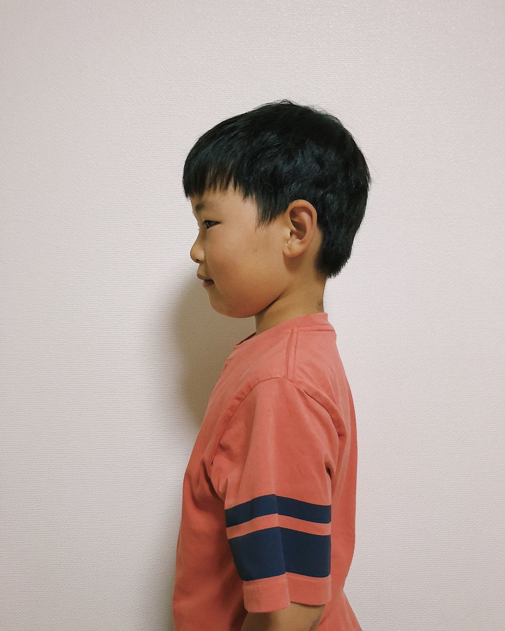 childhood, child, boys, indoors, men, one person, males, standing, wall - building feature, studio shot, casual clothing, white background, looking, innocence, lifestyles, waist up, leisure activity, hairstyle, contemplation