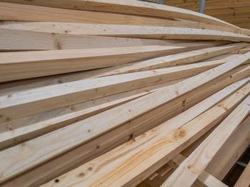 Pile of long square section wooden sticks, slightly bent
