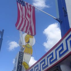 Low angle view of flag against blue sky