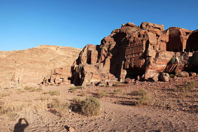 Rock formations on landscape against blue sky