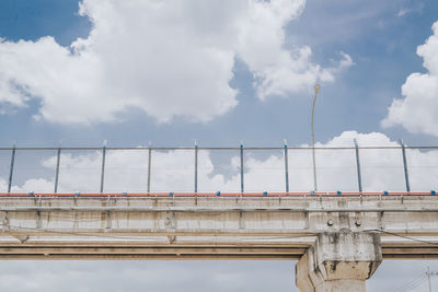 Low angle view of bridge against cloudy sky
