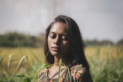 Portrait of woman looking away on field