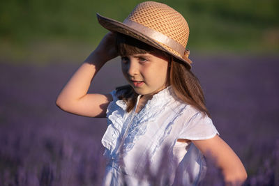Portrait of girl wearing hat standing on field