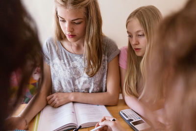 Teenage girls studying together at home