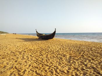 Boat on beach against clear sky