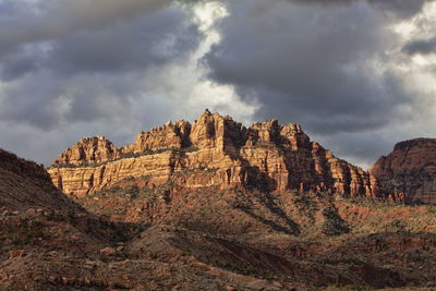 Rock formations on landscape against cloudy sky