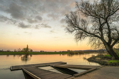 Scenic view of river against sky at sunset