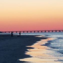 Scenic view of beach against clear sky during sunset