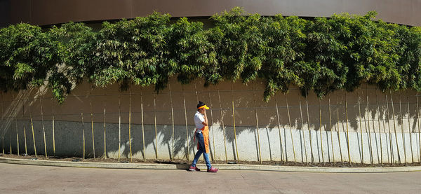 Rear view of man standing by footpath