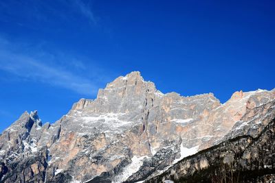 Low angle view of rocks against blue sky