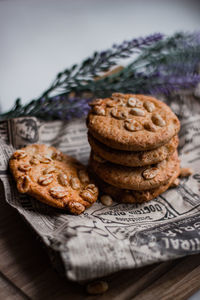 Peanut cookies on a newspaper and a wooden board and lavander. dark and moody. light breakfast. 