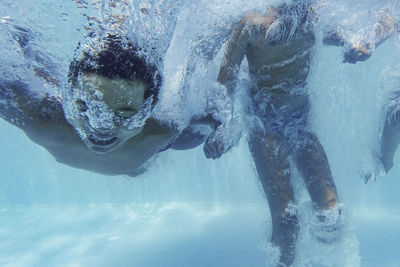 Happy children jumping into a swimming pool