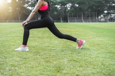 Side view of woman with arms raised on field