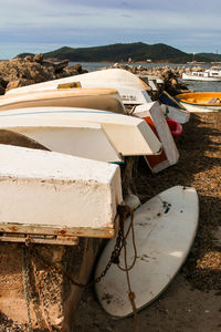 Close-up of boats moored at beach against sky