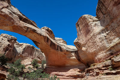 Low angle view of rock formation against clear blue sky