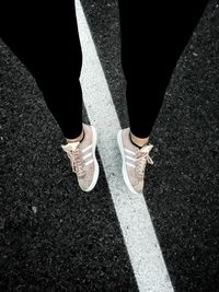 Low section of woman standing on road