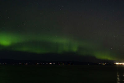 Scenic view of sea against sky and aurora at night