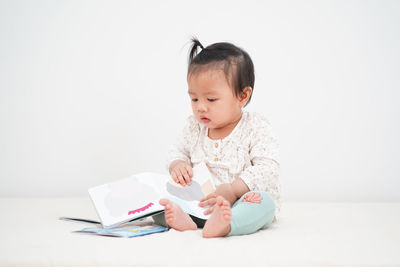 Cute boy sitting on book