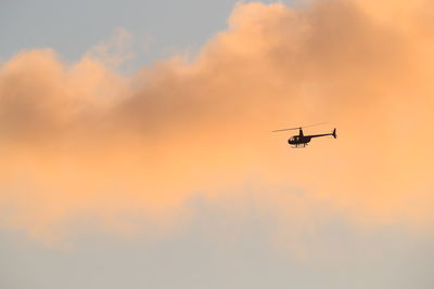 Low angle view of silhouette airplane against sky during sunset