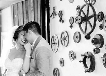 Couple embracing against machine parts hanging on wall