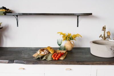 Bright, modern kitchen with stone sink. loaves of fresh homemade bread and a sprig of tomato