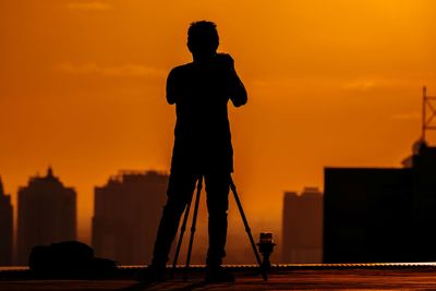 Silhouette man standing against sky during sunset