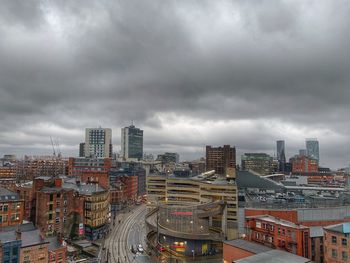 High angle view of street amidst buildings against cloudy sky