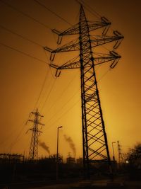 Low angle view of silhouette electricity pylon against sky