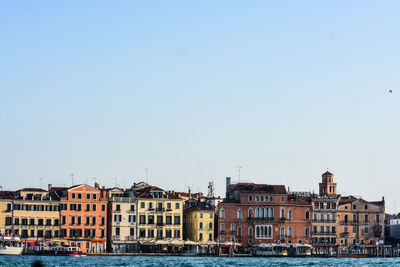 Buildings in city against clear sky