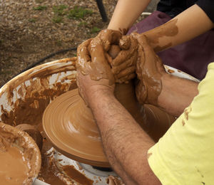 High angle view of people making pots on pottery wheel