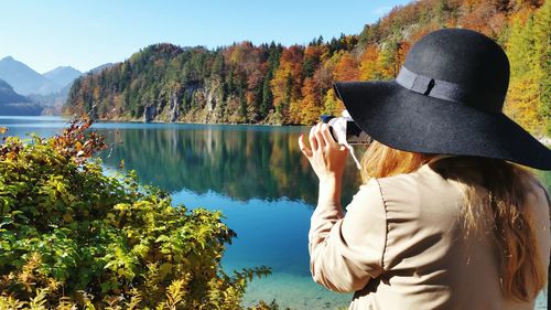 Rear view of man standing on lakeshore