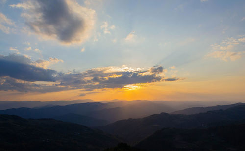 Scenic view of silhouette mountains against sky during sunset